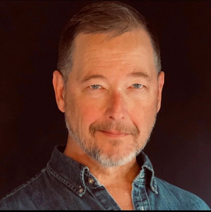 Actor portrait of Dr. David Lowe wearing a denim shirt